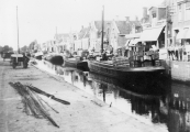 Het beurtschip Tjerk Hiddes van Bauke v/d Werf ligt hier op haar vaste ligplaats aan de Kerkewal. Achter op het schip liggen lege groentekisten van Van der Schoot.