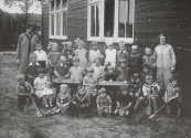 1927 - 1928  De Nutsbewaarschool met op de bovenste rij van links naar rechts:Wim van der Meulen,Mina Rinsma,Aaltje van der Heide,Betty Otter,Tjitske(van Hessel) de Vries,Wimmie Teyema,Sjoerd Nauta,Jannie van der Wijk,Freddy de Jong. Tweede rij:Geert Tasma,Henny de Vos,?,Ypie van der Vliet,Jantje Blaauw,Mea Menalda,Lutie de Boer,Klaske de Vos. Naast de tafel op stoeltje:Jo Rinsma.Voor de tafel op stoeltje:Corrie Sijtsema. Rechts van de tafel:Geertje de Vos.Op de kruiwagen links:Jelle de Boer. Voor de tafel:Wout Oosterhout,Harm Petter,Janke van der Meer,Harmke Oudeboom. Op de kruiwagen rechts:Nico Sjollema,Maartje Numan.Linksboven:Juffrouw Fokje de Jong. Rechts boven:Juffrouw H.Grevenstuk.