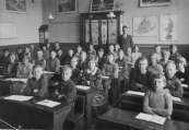 O.L.school 1931-1932. 1e rij banken rechts: Harm Jan Bijlsma, Wiebe de Boer, Ernst Huisman, Aaltje v/d Heide, Hennie de Vos, Wimmie Teijema, Sjoerd Nauta, Piet Mast. 2e rij: Wouter Oosterhout, Klaas v/d Wal, Wobbiena Drenth, Bettie Otter, Jentsje Nauta, Geert v/d Akker, Doetie Westra, Dineke Wagenaar, Gerrit Krist, Jan Zuiderbaan, Jantje Meijer, Stien de Jong. 3e rij: Rienie Riedstra, Geertje Crom, Koos Mensinga (Loopstra), Auke Klazema, Jan Sijtsema, Jaap Schilstra, Anneke v/d Sluis, Sabina Jonkers. 4e rij: Heine Drenth, Wiepie Keuning, Willy v/d Pol, Pietje Nutters, Jantje de Groot, Jitske v/d Werf, Boukje v/d Wijk. Onderwijzer Jouke de Vos. 