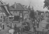 Optocht op 5 mei 1945, hier op de Stationsweg/ Hoofdstraat. Links de rietwinkel van Louw Kniezenburg.