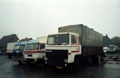 Kermis transport op een rij langs de Nieuwstraat/Marktplein tijdens de opbouw van de Gordykster najaarskermis in het jaar 1986, van links naar rechts: aanhanger behorend bij de Autoscooter van Nico Sipkema & zoon uit Apeldoorn, Mercedes behorend bij de bootjesmolen 