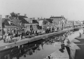 Optocht op 5 mei 1945, hier aan de Molenwal. Op de vaartkant liggen de resten van de bovenbouw van de hoofdbrug die de Duitsers in april hadden laten opblazen.