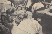 1960 Oktober, Het was nog rustig in de vermaakssektor, voorzover men daarbij bloot stond aan de regen. En daarvan hebben de kleintjes geprofiteerd, er was plaats en aandacht voor hen. Hier zweven vier meisjes in een vliegmachine, aan de gezichten van de kleinsten is te zien, hoe snel en hoe móói het ging.