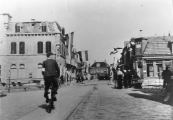 April 1945. Een lid van de Binnenlandse strijdkrachten met armband fietst richting hoofdbrug. Het Postkantoor links was zwaar beschadigd door het vuurgevecht met de Duitsers die de brug gingen opblazen. Er werd een grannat door een der dakkapellen geschoten. Tijdens het gevecht kwam Gerk Numan om het leven.