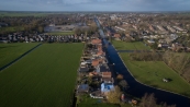 Luchtfoto gemaakt op 28 november 2015. Op de foto is het braakliggende fabrieksterrein van Timmerfabriek de Vries goed te zien. De laatse puinresten liggen klaar om opgeruimd te worden. Op de voorgrond de in aanbouw zijnde woning van fam. Dijkstra op het Easterein.