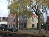 Diep pand met volledige verdieping onder zadeldak met voor- en achterschild. In voor- en zijgevel hoge zesruitsvensters. Dit pand behoorde bij de Synagoge
(die rechts van de woning gestaan heeft) als woning voor de leraar.
