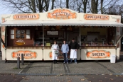 25 jaar oliebollen bakken in Gorredijk. Als je november en december praat over oliebollen dan heb je het over de familie Tilstra. Het was 1987 toen de familie voor het eerst open ging met hun oliebollenkraam aan het Hofland te Gorredijk. Dit jaar viert de familie hun 25-jarige jubileum. In de loop der jaren is er wel het een en ander veranderd. Zo woonde de familie in de begin jaren tijdens de oliebollen verkoop op het marktplein in hun huis op wielen. De zonen Wijnard en Patrick kregen dan gedurende die periodes les op de plaatselijke openbare basisschool De Flambou. Sinds de herinrichting van het marktplein was er echter geen plaats meer voor de woning van de familie waardoor ze sindsdien op de thuisbasis in Warfhuizen verblijven. Wat ongewijzigd is gebleven, is dat de kraam nog steeds op dezelfde plaats aan de Lijnbaan staat en zij ze nog steeds even lekker bruin voor menigeen bakken. Op de foto overhandigd Jurjen Haagsma een bloemetje aan Jitty Tilstra.
Foto: Henk Stoelwinder.