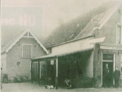 Eerste generatie herenkappers De Vos.
Mijn grootvader, Jan Heine de Vos, heeft tot 1917 als bediende gewerkt in cafe ‘De Veehandel’ op de foto staat hij in de deur opening rechts naast zijn baas Feitze de Groot. Het scheren koste destijds 5 cent, een borreltje 3 cent en een sigaar 2 cent. Tot in de jaren 60 was er op deze locatie een horeca bedrijf gevestigd. Het eindigde destijds met de roemruchte bar dancing De Kûper, die eind jaren 60 in vlammen opging. Daarna liet de fa. Rudolphy er een meubelzaak op bouwen. Dit werd aan het eind van de vorige eeuw alweer vervangen door het huidige woon winkelcomplex. Foto: Jan de Vos