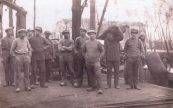 Foto van het lossen van een beurtschip, persoon op het midden van de foto van drie mannen is Pieter van der Woude. Foto gemaakt rond 1930. (foto via Hendrik Liemburg)