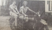 Zomers gekleed op de Harley Davidson van de P.E.B.er De Bruin. Deze was ingeschakeld bij het tot stand brengen van het transformatorgebouwtje vlakbij de viersprong in Kortezwaag omstreeks 1935/1936. De Buin was ingekwartierd bij smid Johannes Koelma. Op de motor diens dochters Nel (links) en Anneke. Op de achtergrond links Het Witte Huis (nog met balkon) , geheel rechts de eveneens wit-begevelde woning van Gosse de Boer , nu Hilbrand Rudolphy. (foto: Hans de Jong).