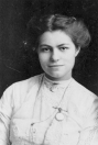 Potret van Cornelia (Kee) van Ossenbruggen 1915. Adriana de Haan, weduwe van Siebren van Ossenbruggen, emigreerde in 1910 met haar zes kinderen vanuit Gorredijk naar Noord Amerika. Zij was afkomstig uit een vooraanstaande Gorredijkster familie. Haar man, koperslager van beroep, was twee jaar eerder op 36-jarige leeftijd in Gorredijk overleden, waar het gezin in 1903 vanuit Sneek was komen wonen. De oudste dochter Cornelia (Kee), geboren in 1894 was in Gorredijk hulp geweest bij in het gezin van schoolmeester Thomas van der Schaaf.