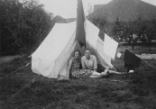 Jan Eisenga en zijn vrouw kamperen. De vlag van de Geheelonthoudersbond staat roerloos voor de tent.